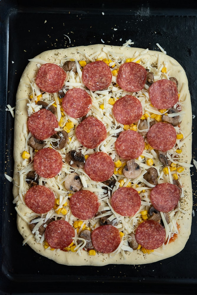 pizza na grubym cieście przed upieczeniem 