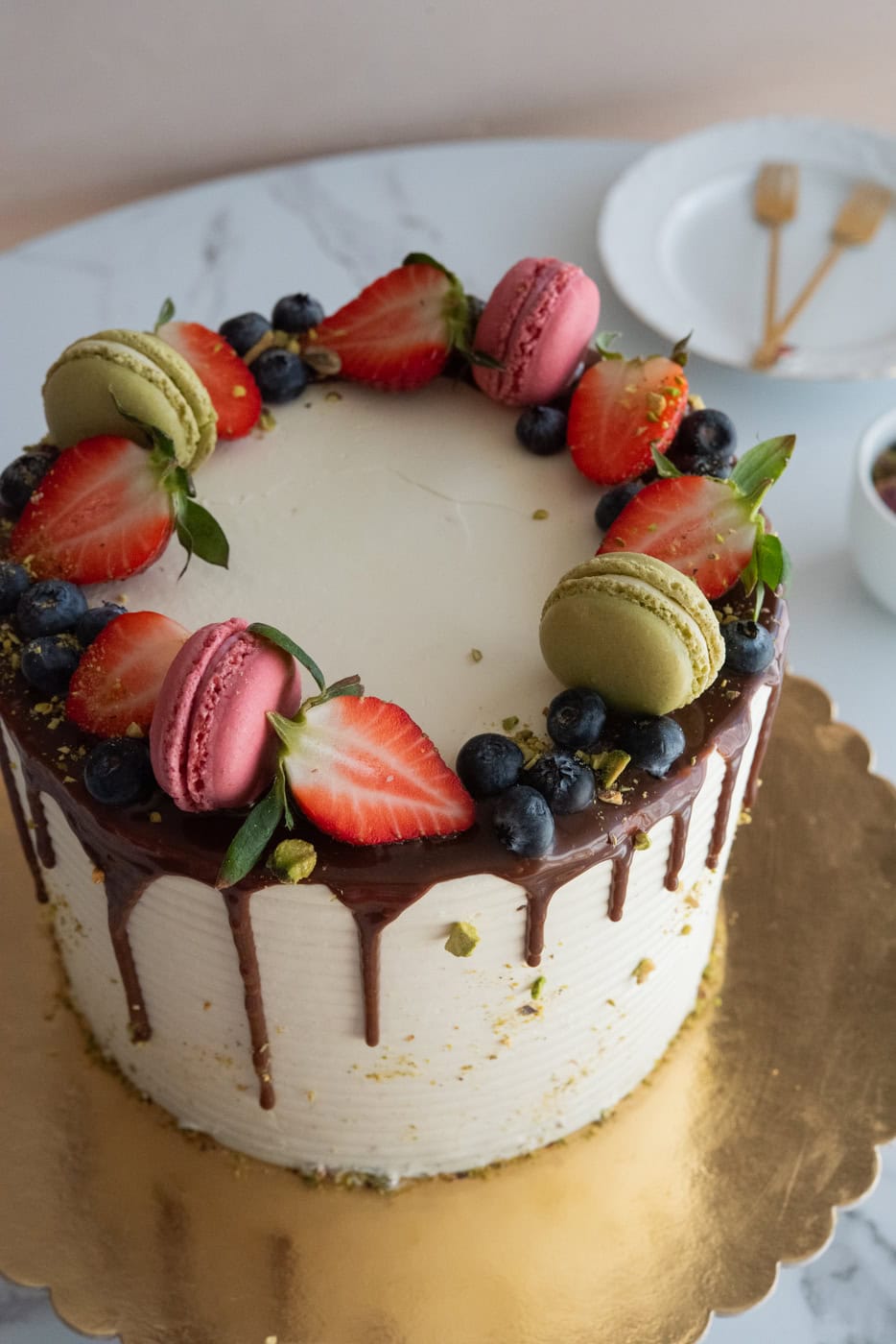 tort pistacja malina z dripem czekoladowym, owocami i makaronikami